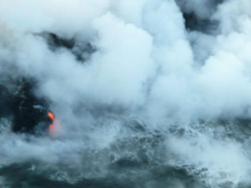 ハワイ島の上空からみる海に流れ落ちる溶岩